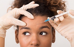 person receiving a BOTOX injection in their forehead