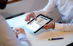 Dentist and patient reviewing dental insurance benefits on a tablet