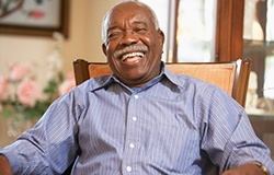 Man sitting in a chair and smiling while laughing