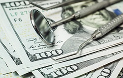 dental instruments with a stack of money underneath