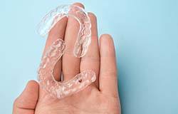 Man holding clear aligners for Invisalign in Orange Park
