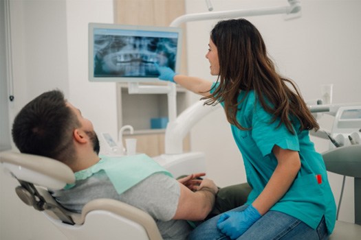 A dentist looking at X-rays with a patient