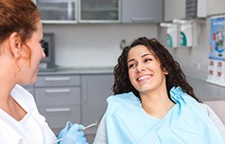 Woman in dental chair smiling at dentist