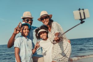 Smiling family taking a selfie on the beach