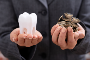 woman holding money and tooth in hands at dentist