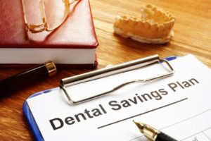 dental savings plan with clipboard on desk 