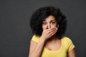 woman hides her cracked teeth during COVID-19