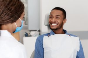 Dentist and patient discussing the difference between Invisalign and veneers