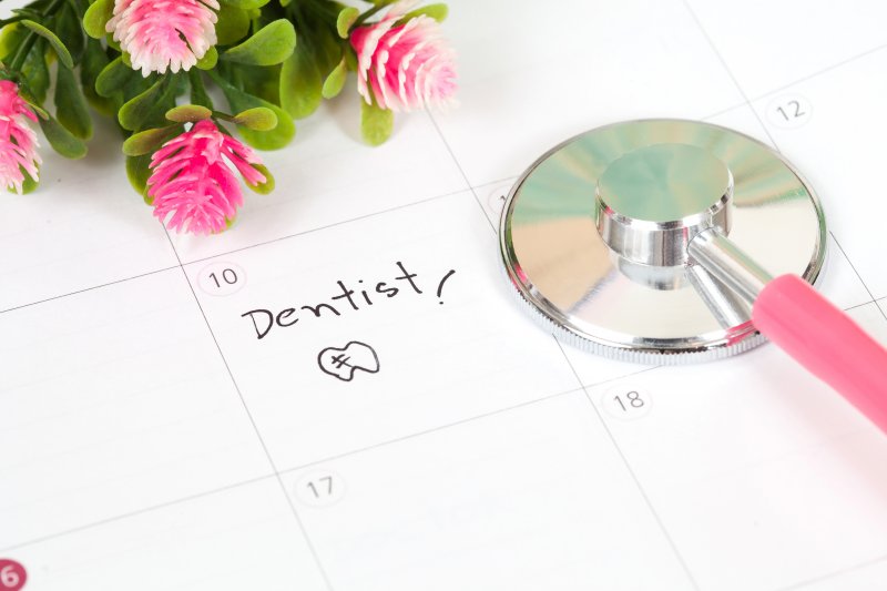 calendar with reminder to visit dentist and toothbrush