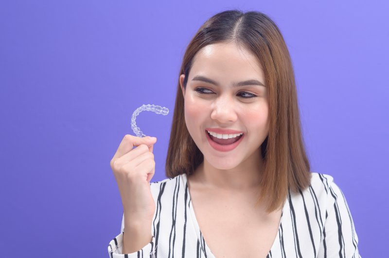 woman holding clear aligners in Orange Park