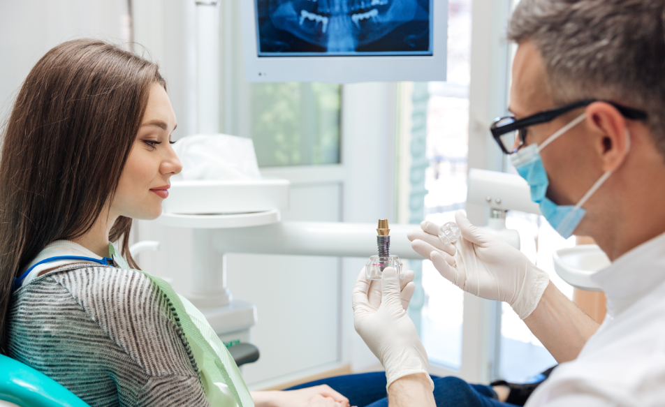 Dentist showing patient a dental implant