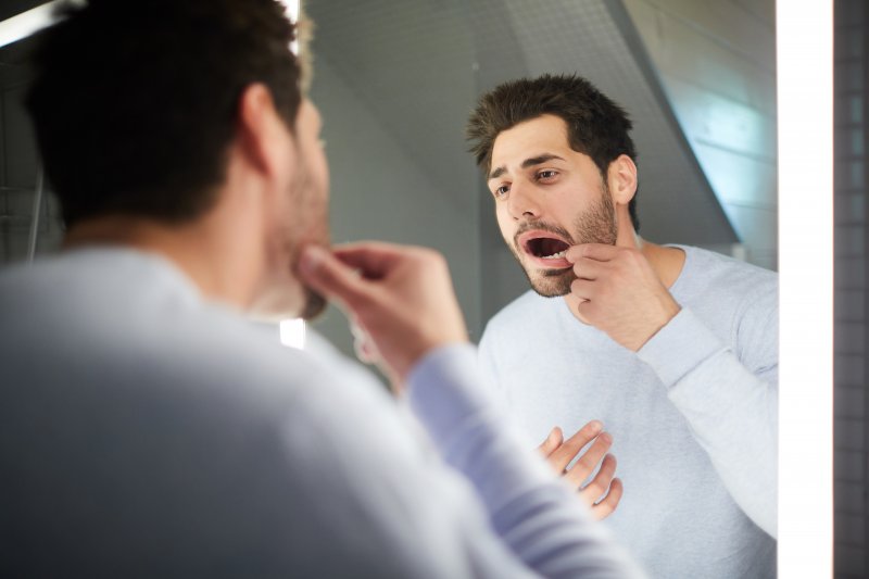 A man checking his mouth for gray teeth